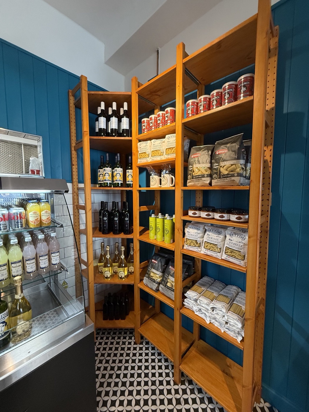 Shelves of Mediterranean deli goods inside Humble Hands Deli, wine, pasta and tinned tomatoes