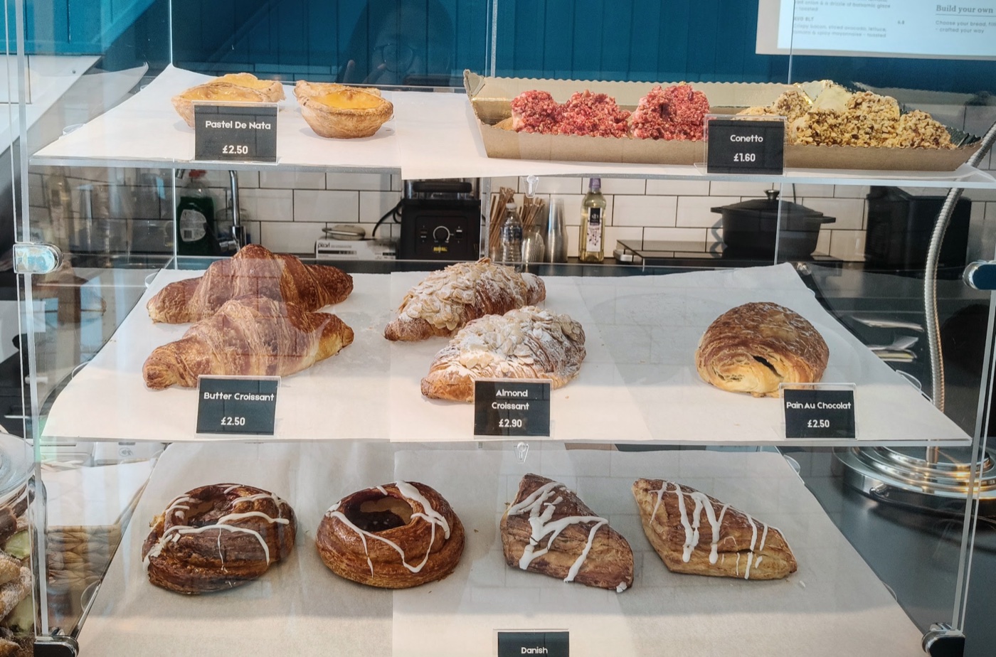 The pastry case at Humble Hands Deli, with croissants, pastel de nata and danishes priced up
